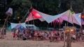Bei Einbruch der Dämmerung füllt sich die Wiese: Unter dem beleuchteten Zeltdach genießen Gäste Musik und Sommerstimmung